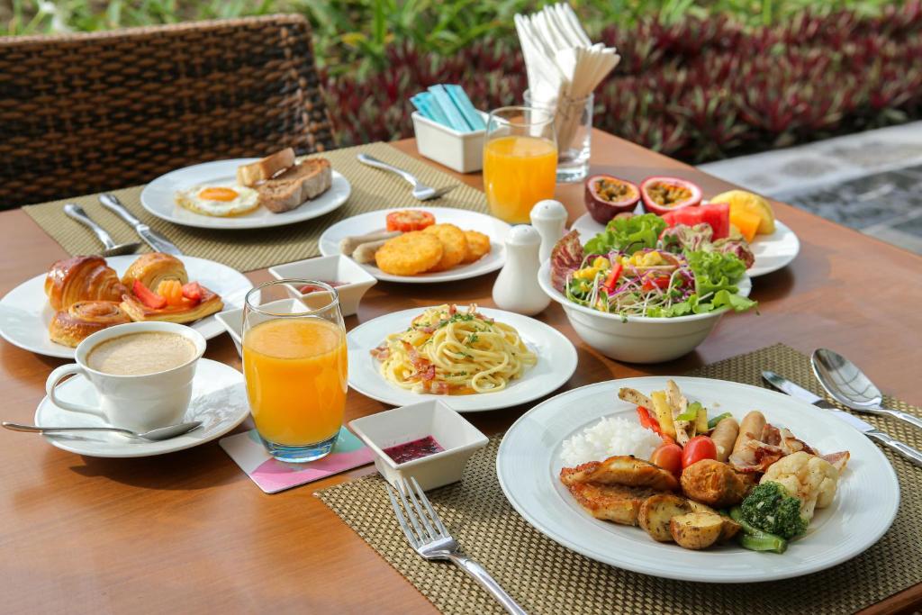 A generously laid outdoor table combines hot dishes, pastries, fruit, salad, coffee and juice.