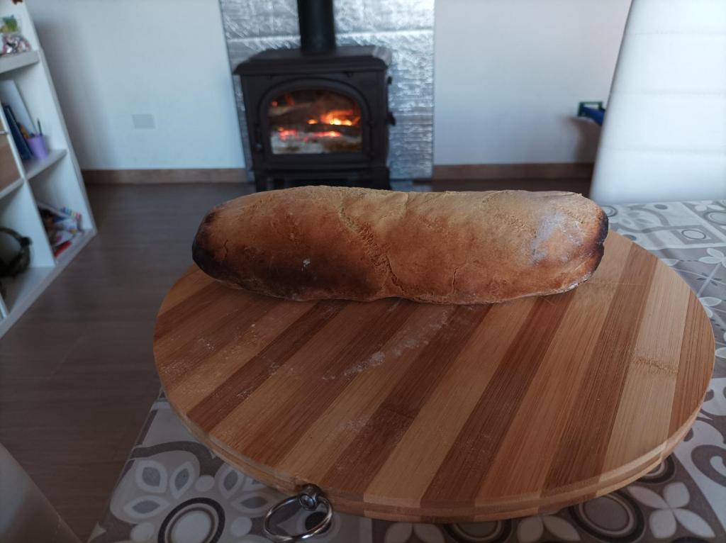 una hogaza de pan sobre una mesa de madera con chimenea en Appartamento, en Montelepre