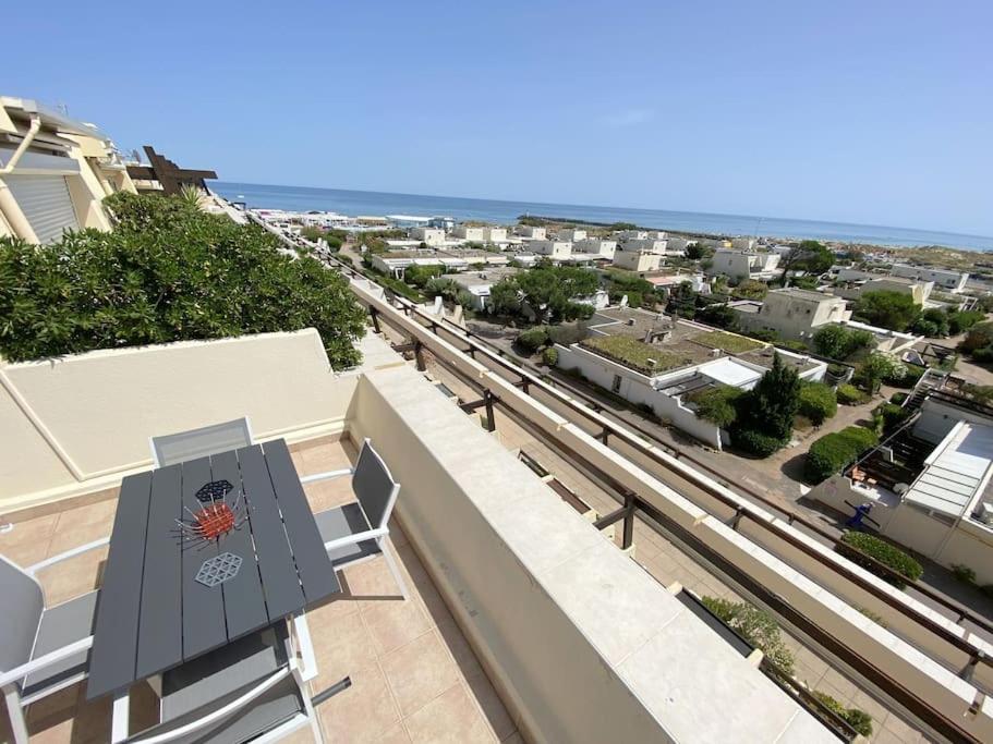 un balcon avec un banc et une vue sur une ville dans l'établissement Studio 383, Port Nature 3 au village naturiste, au Cap d'Agde