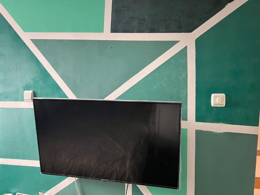 a flat screen tv on a green wall at Casa Iuliana in Valcea