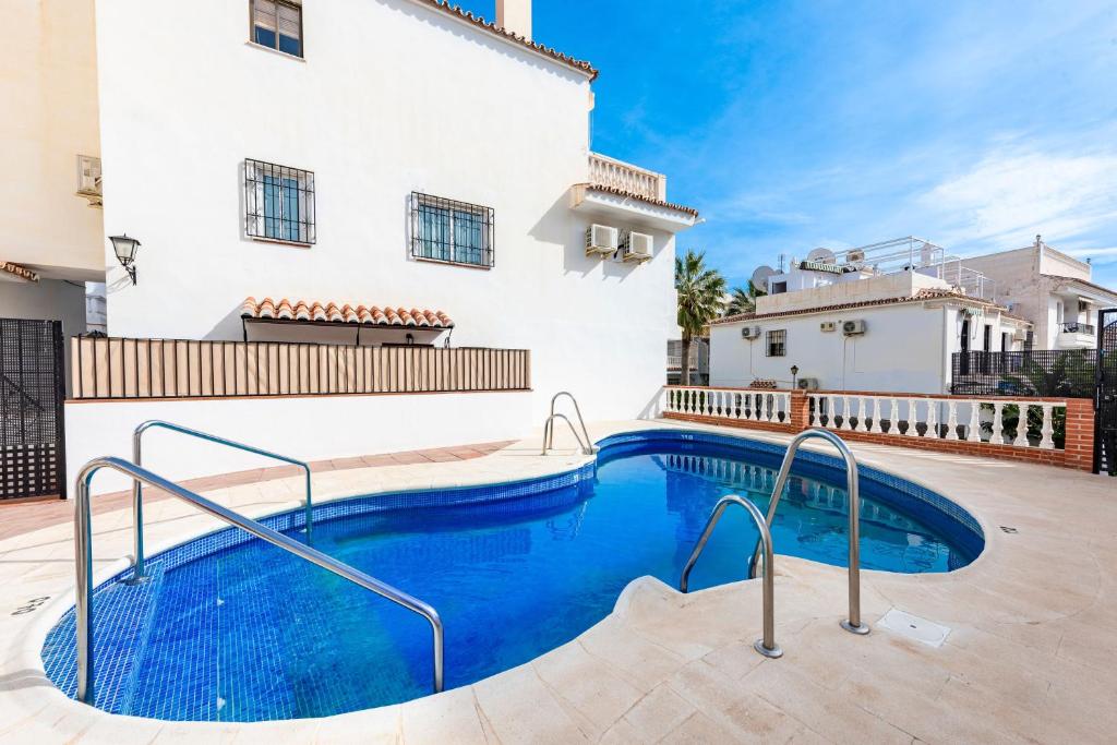 a swimming pool in front of a house at Nerja centro, playa carabeo in Nerja