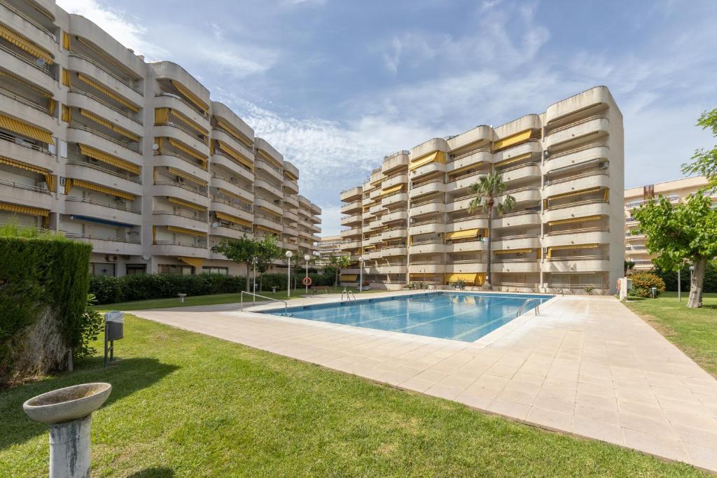 een appartementencomplex met een zwembad in een tuin bij Córdoba 2 Dormitorios Arysal in Salou