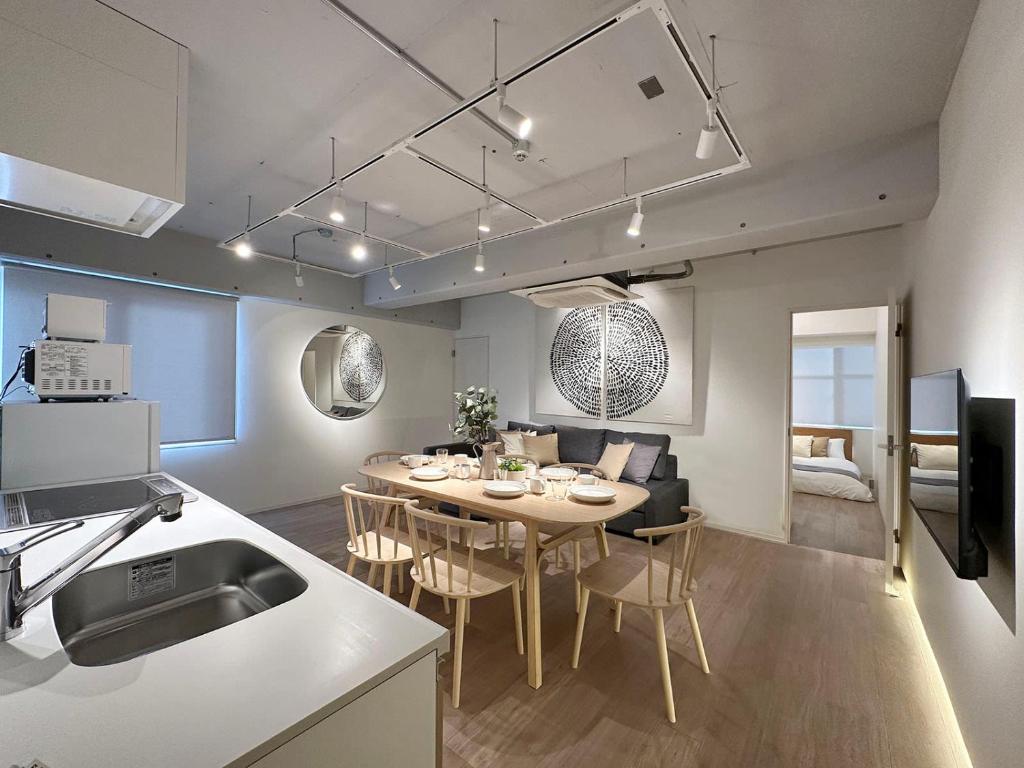 cocina y comedor con mesa y sillas en bHOTEL Art Bldg - Modern 2BR City Center for 8ppl en Ōsukachō
