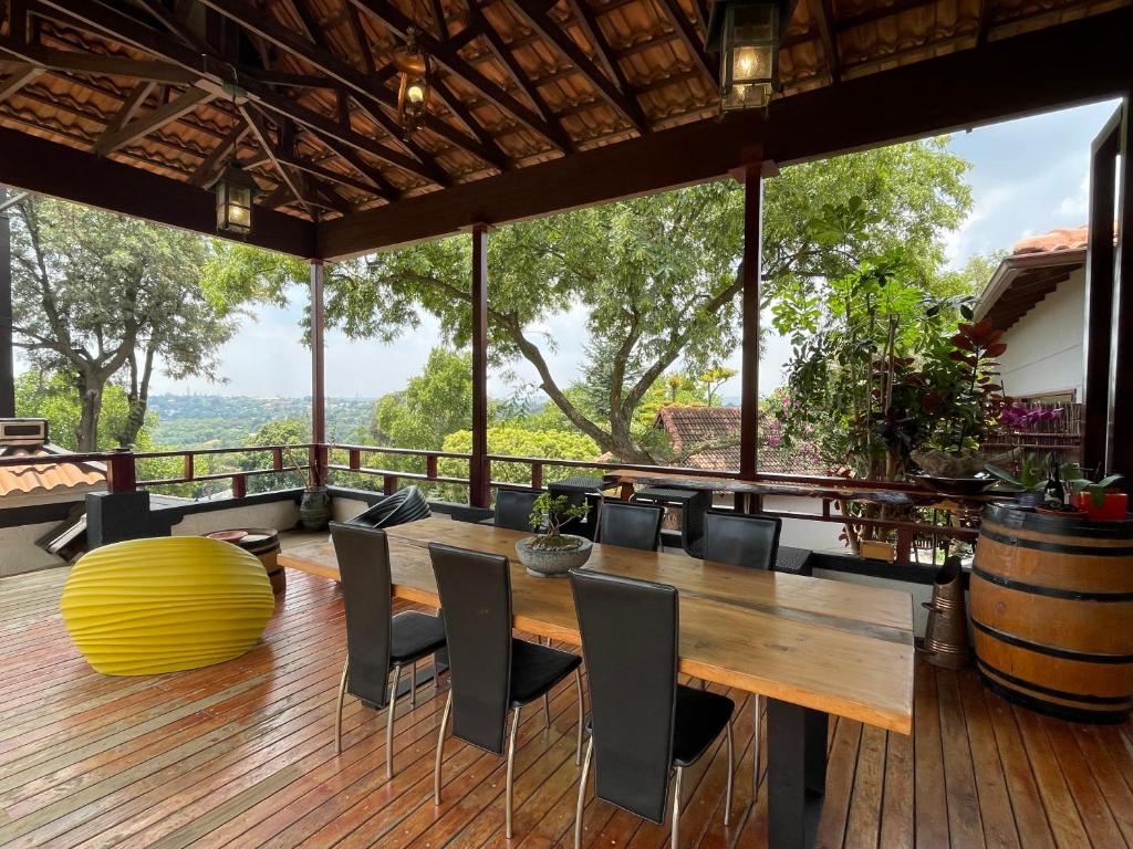 een eetkamer met een tafel en stoelen op een terras bij Oasis On Lily Northcliff in Johannesburg
