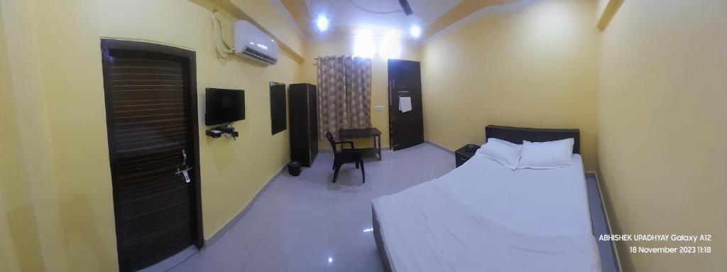 a small room with a bed and a chair in it at THE KNIGHTS INN in Lucknow