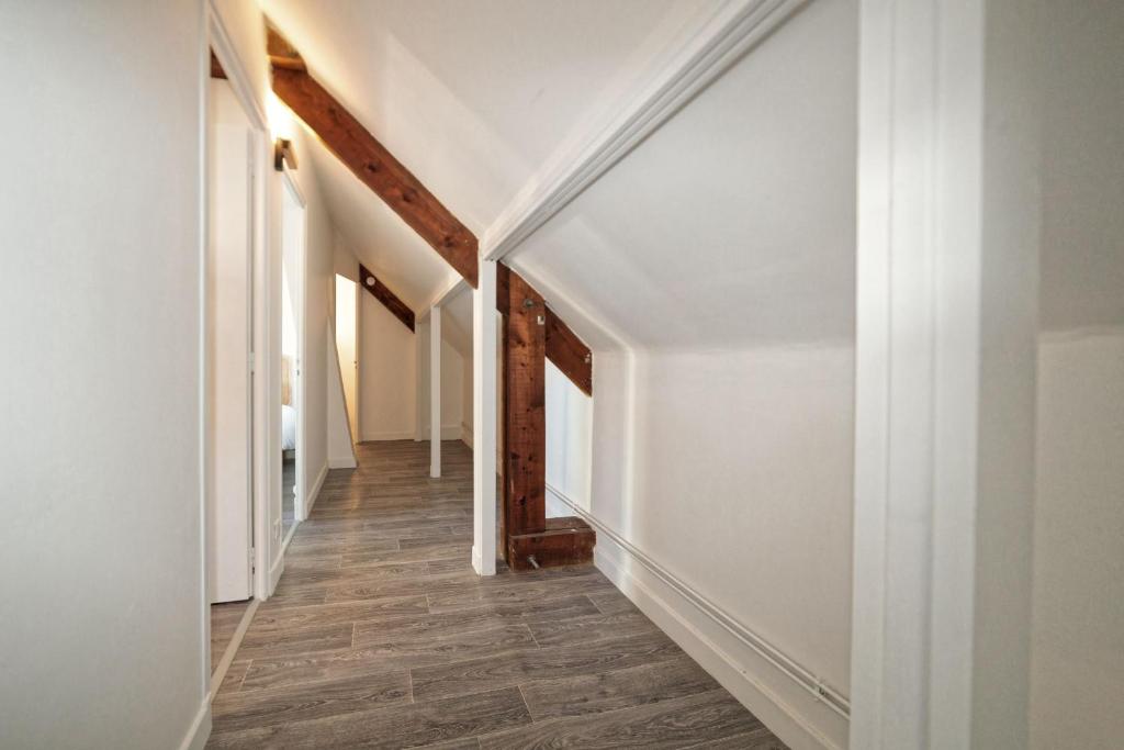 an empty hallway with white walls and wood floors at Maison 15 couchages idéale pour séjour en groupe in Clermont-Ferrand