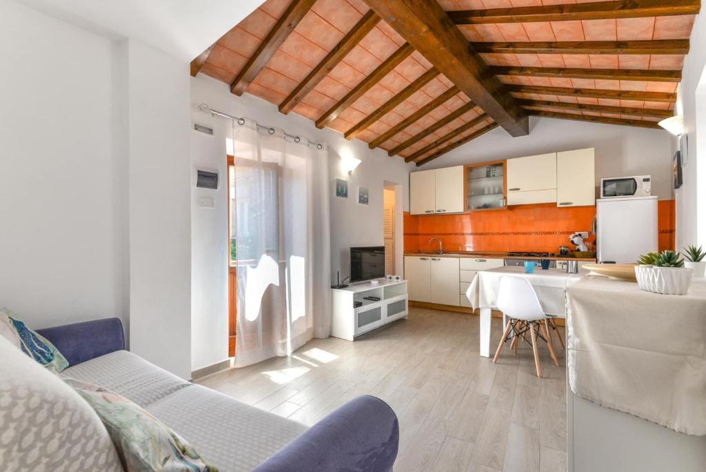 a living room with a table and a kitchen at Casa Arancio in SantʼIlario in Campo