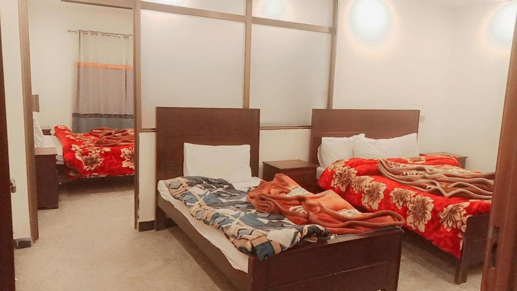 sypialnia z 2 łóżkami i lustrem w obiekcie The Lavish Inn w mieście Murree