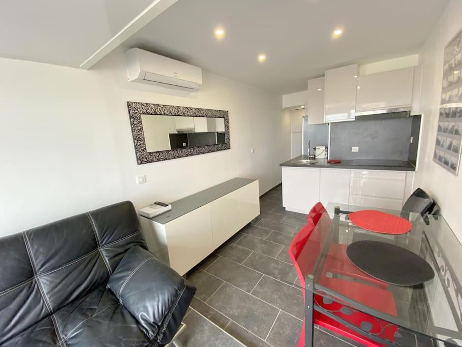 un salon avec un canapé et une table en verre dans l'établissement Appartement 88, Port Nature au village naturiste, au Cap d'Agde