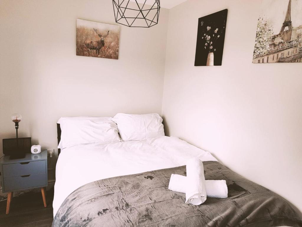 a bedroom with a bed with two white crosses on it at LARGE 3 BEDROOM HOME, 3 BATHROOMS, FREE PARKING, FAST WIFI in Belfast