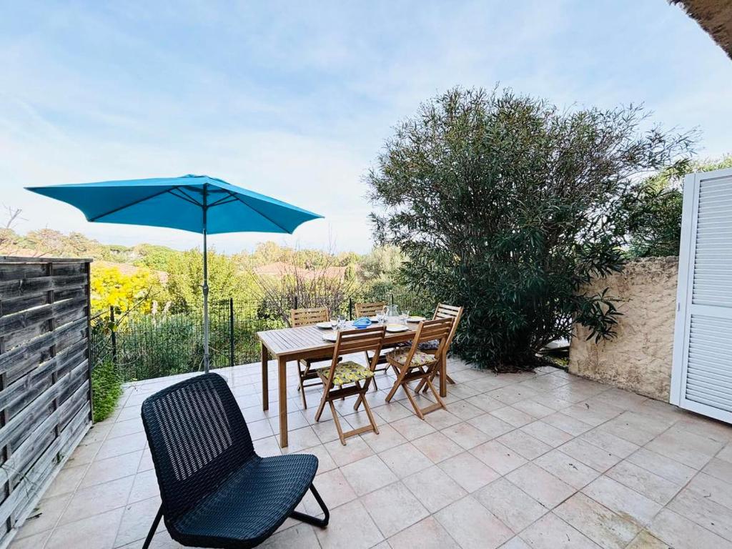 une table et des chaises avec un parasol sur une terrasse dans l'établissement Appartement Aria Marina 2 Lumio, à Lumio