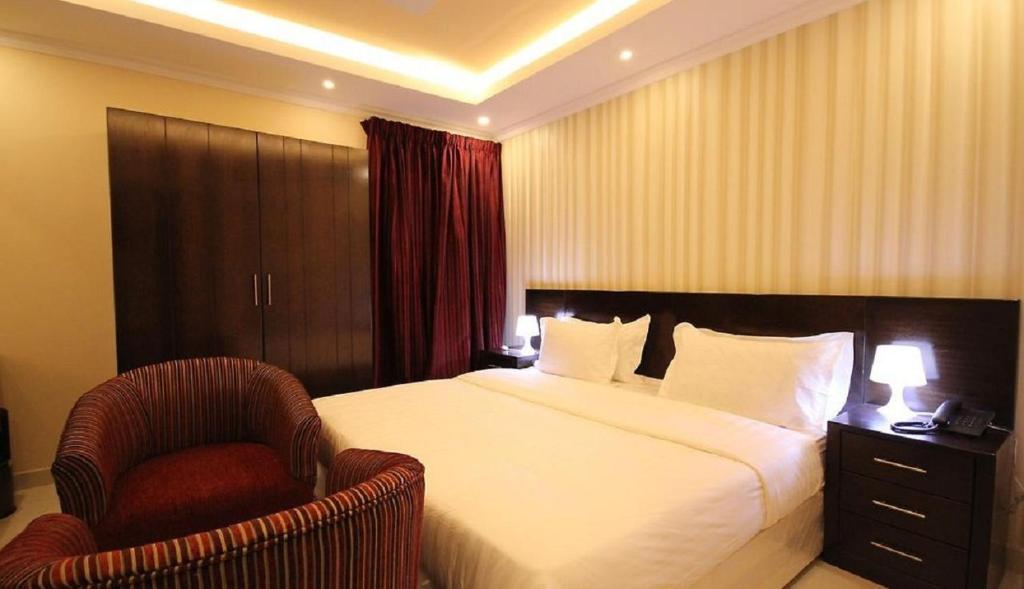 une chambre d'hôtel avec un lit et une chaise dans l'établissement اجنحة أروى سويتس الدمام Arwa Suites Dammam, à Dammam