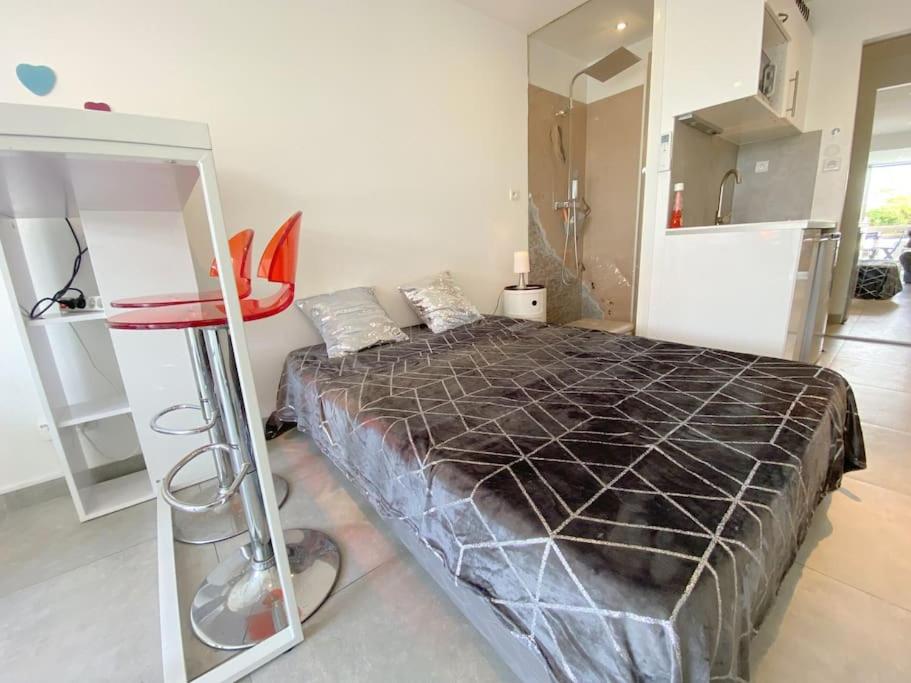 - une chambre avec un lit et un tabouret rouge dans l'établissement Studio 20, Port Nature 2 au village naturiste, au Cap d'Agde
