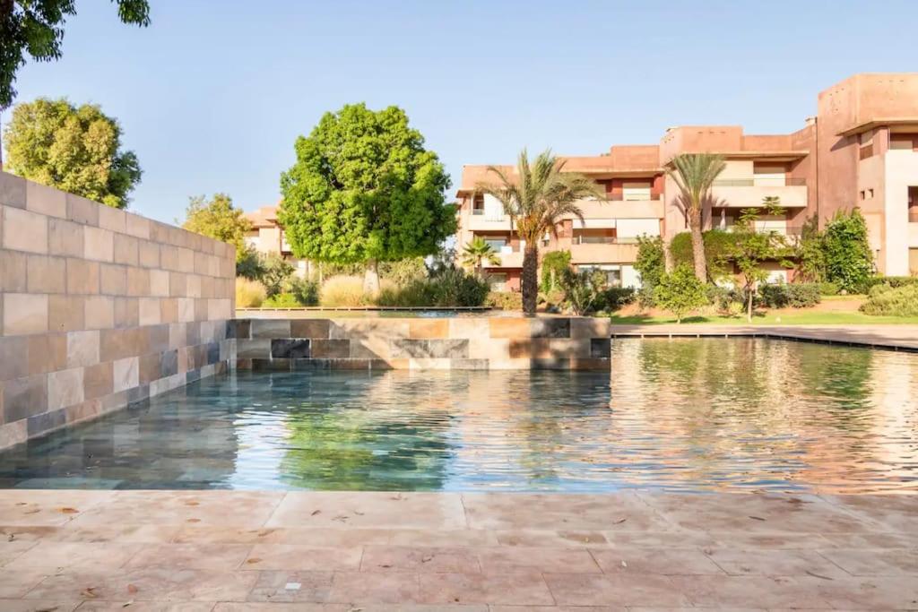 une piscine en face d'un bâtiment dans l'établissement Appartement de Luxe à Marrakech!, à Marrakech