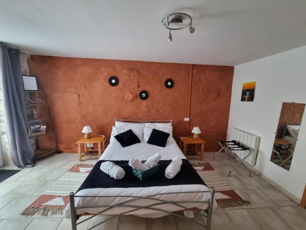 a bedroom with a bed with a orange wall at La Maison des Grands Bambous - L'Angoumois L'Aunis La Saintonge La Boutonne in Louzignac