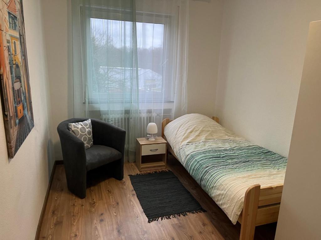 1 dormitorio con 1 cama, 1 silla y 1 ventana en Bruchköbel 4 auch für Monteure en Bruchköbel