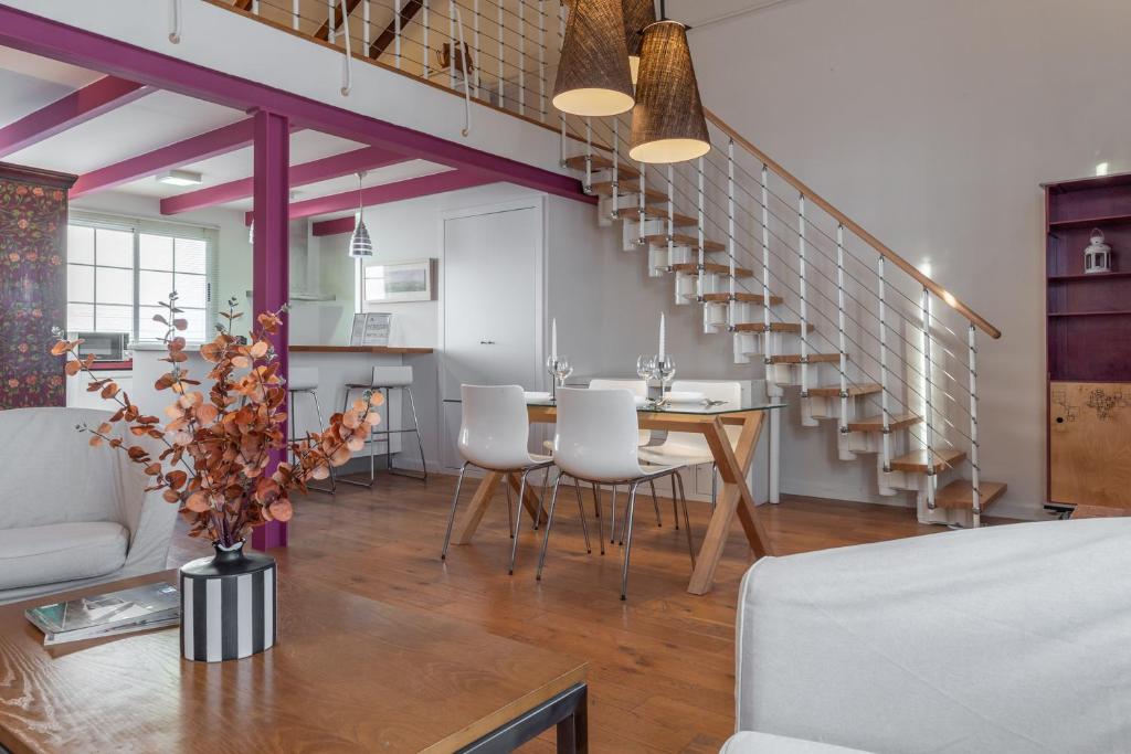 Un comedor con una mesa y sillas blancas. en Únika Homes Porvenir, en Sevilla