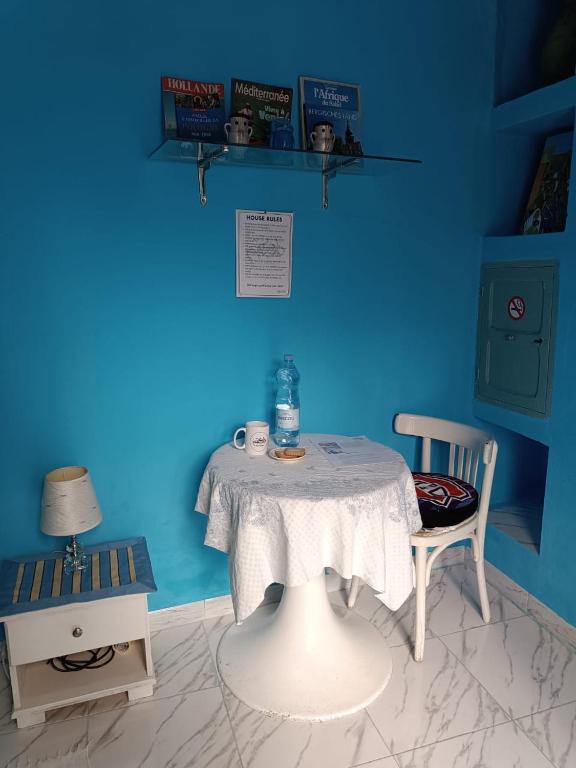 a blue room with a table and a chair at Dar Hkaïem in Sousse