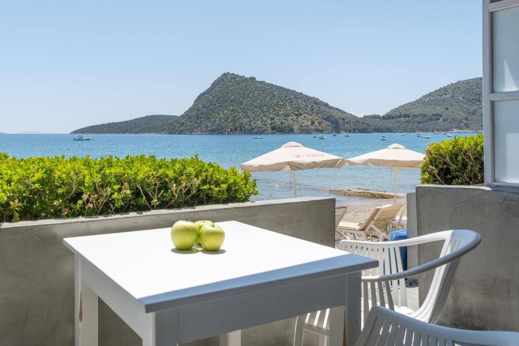 a table and chairs with a view of the beach at Nelly's Apartments in Tolo