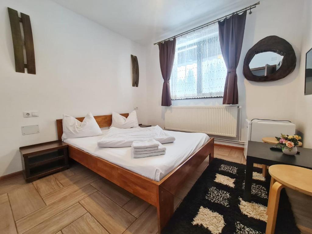 een slaapkamer met een bed, een tafel en een raam bij CABANA FRAM VÂRTOP in Nucet