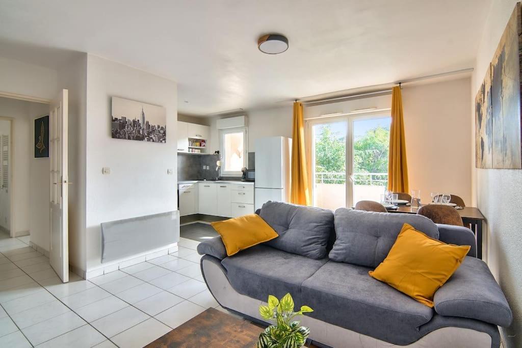 un salon avec un canapé bleu avec des coussins jaunes dans l'établissement T2 Calme et Lumineux à Colomiers proche Airbus, à Colomiers