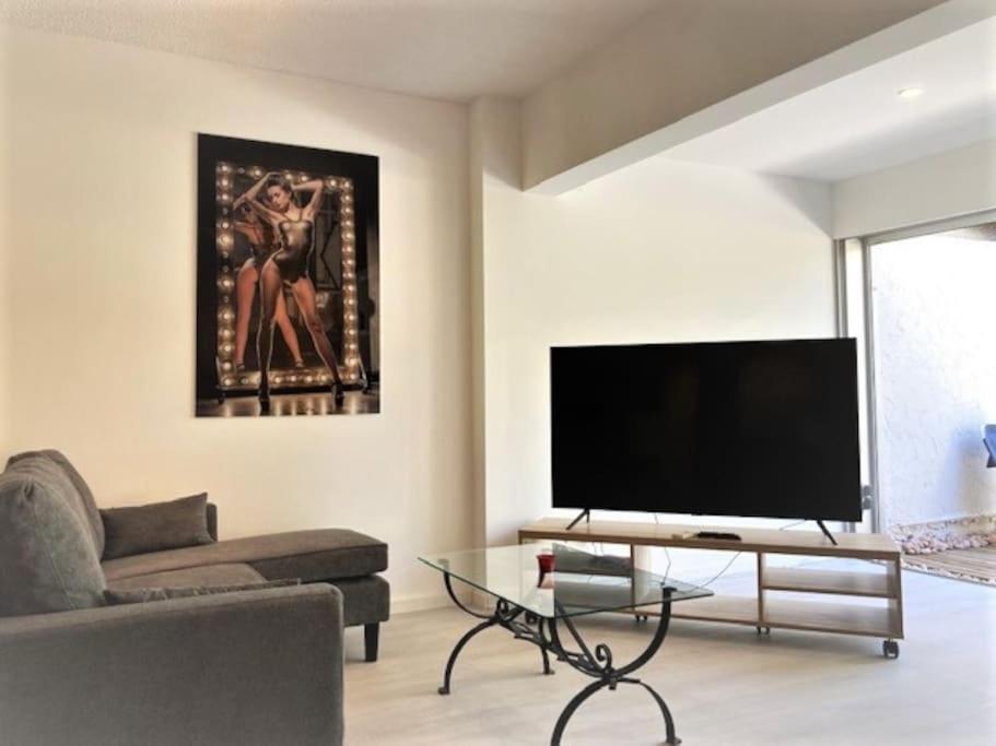 un salon avec une grande télévision à écran plat dans l'établissement Villa 181, Port Nature, au village naturiste, au Cap d'Agde