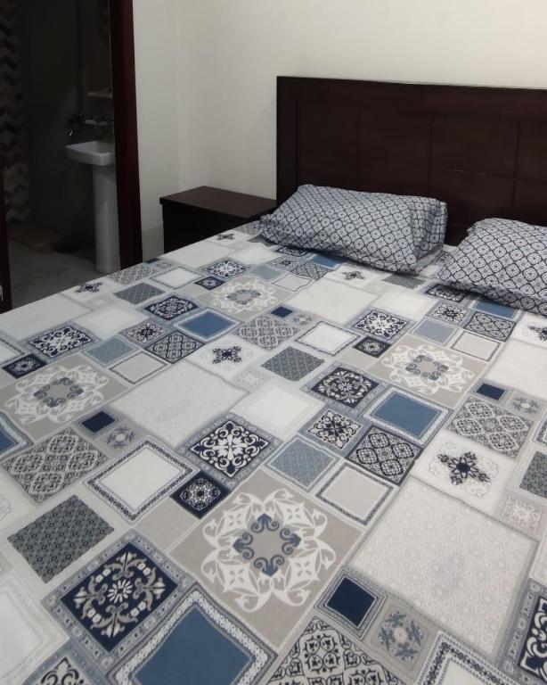 Una cama con azulejos azules y blancos. en Comfy room, en Rawalpindi