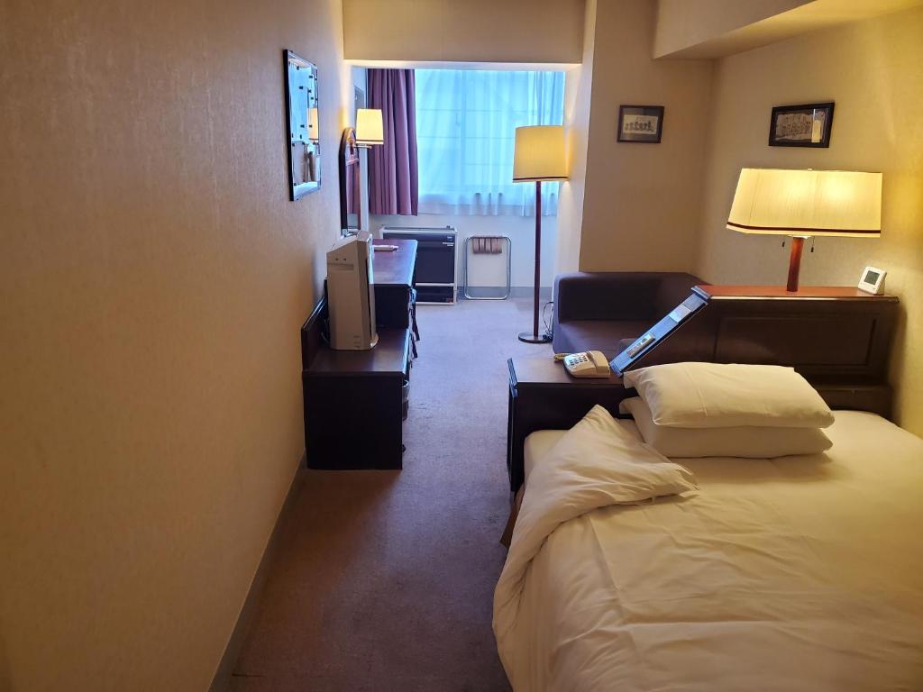 een hotelkamer met een bed en een televisie bij City Pension Zem in Tokyo