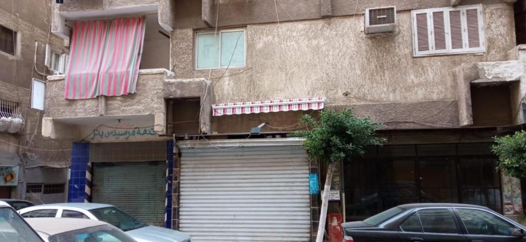 a building with a garage door on the side of it at Flower Roomsللرجال فقط in Alexandria