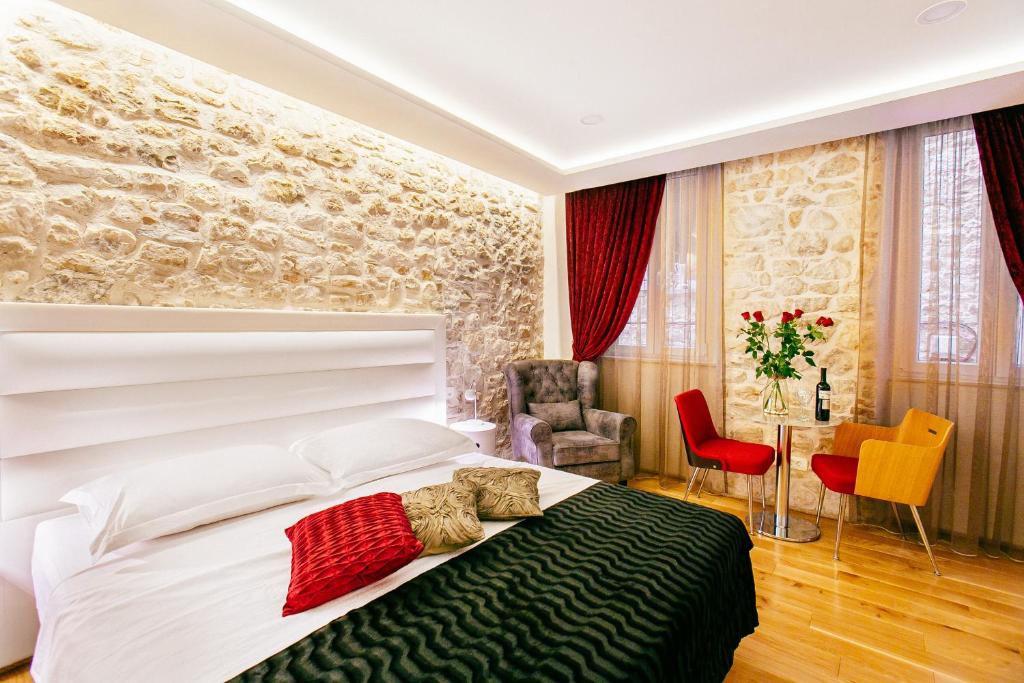 a bedroom with a large white bed and red chairs at Get Split Luxury Apartment in Split