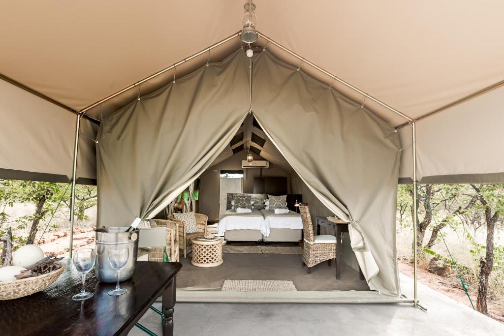 a canopy tent with a bed in it at Mapesu Wilderness Tented Camp in Musina