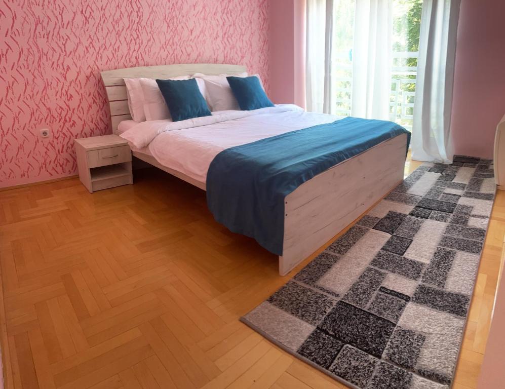 a bedroom with a large bed with pink walls at Charming Modern Condo near City Center Free Parking & Fully Equipped in Skopje