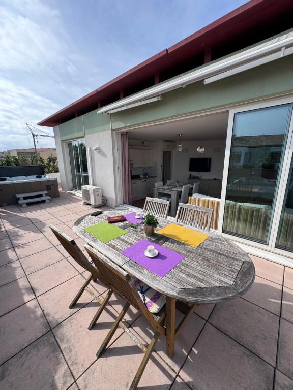 a table and chairs sitting on a patio at Penthouse avec Jacuzzi - Terrasse - Parking - Piscine in Antibes