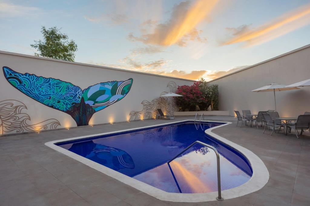 een zwembad met een muurschildering aan de zijkant van een gebouw bij Fairfield by Marriott Los Cabos in Cabo San Lucas