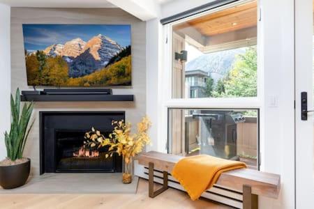 a living room with a fireplace and a tv at Aspen Core Renovated 2 BR, 2 BA with AC in Aspen