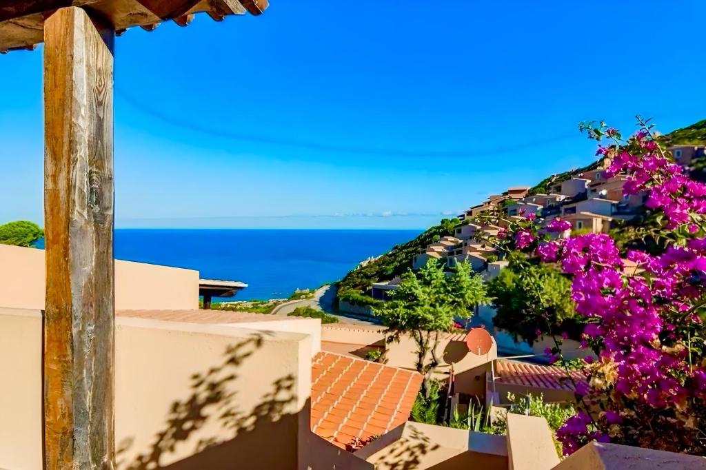 a view from the balcony of a resort with purple flowers at Casa il Bouganville - sea view Costa Paradiso in Costa Paradiso