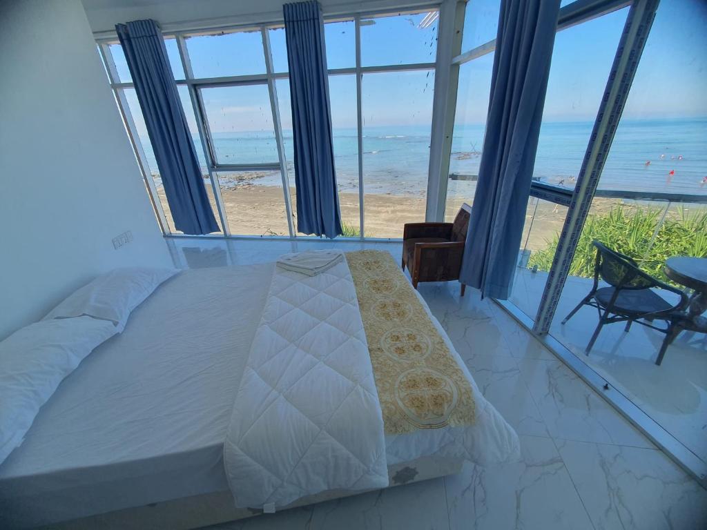 a bedroom with a bed and a view of the beach at Atlantic Resort in Jaliapāra