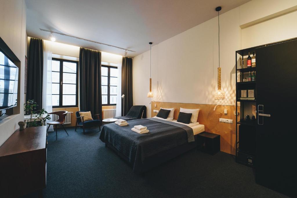 um quarto de hotel com uma cama e uma cadeira em Avatary Miasta em Lublin