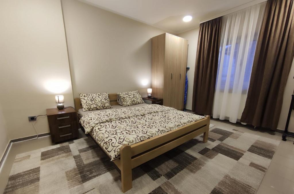 ein Schlafzimmer mit einem Bett und zwei Nachttischen und zwei Lampen in der Unterkunft Prenoćište Lana in Novi Banovci