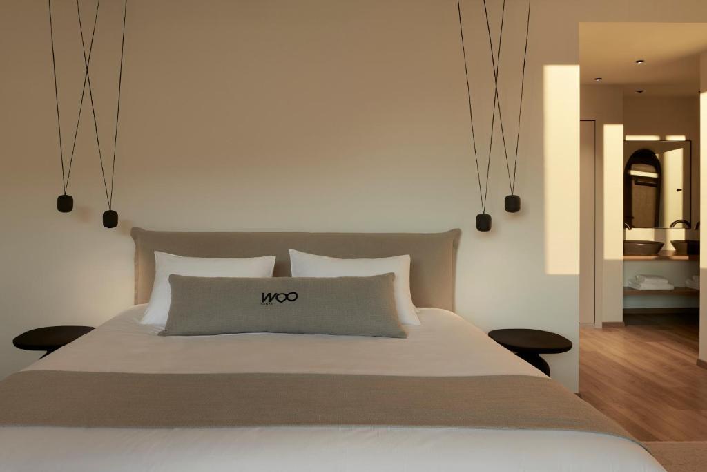 Athens Woo Suites في أثينا: غرفة نوم مع سرير كبير مع علامة nos عليه