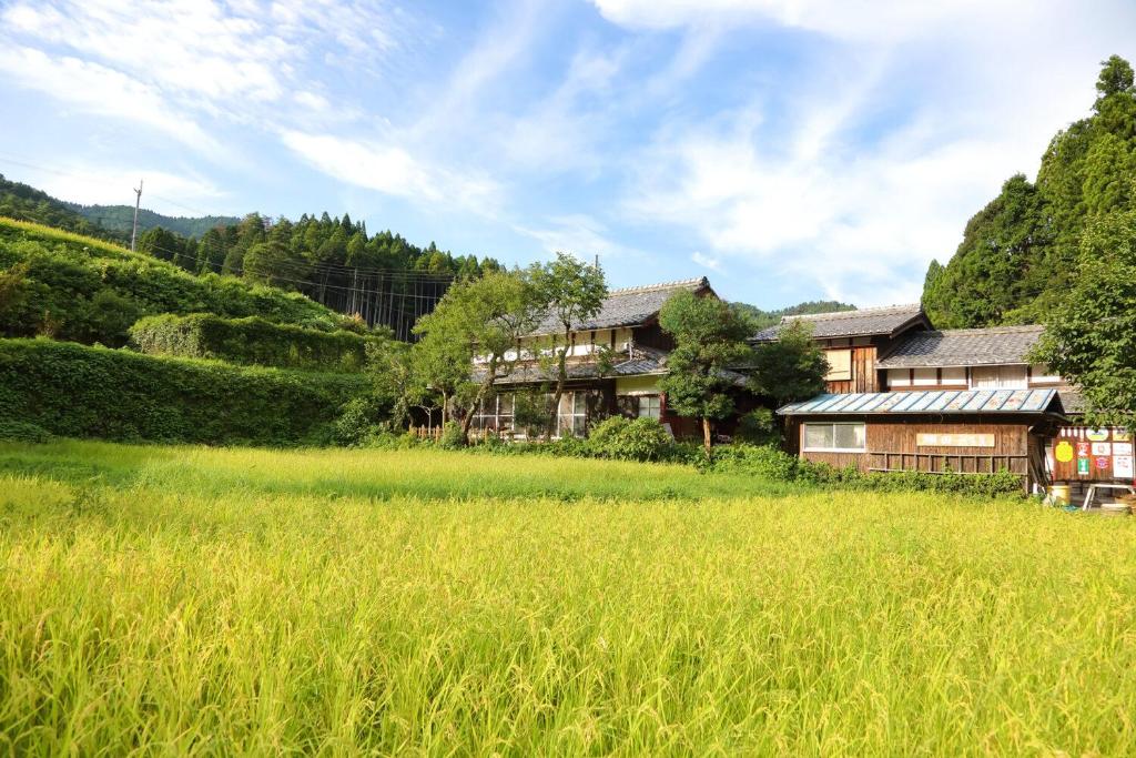 a house in the middle of a field of grass at 棚田ハウス 