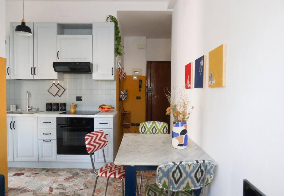 a kitchen with white cabinets and a table with chairs at Sancisi 3 in Santarcangelo di Romagna