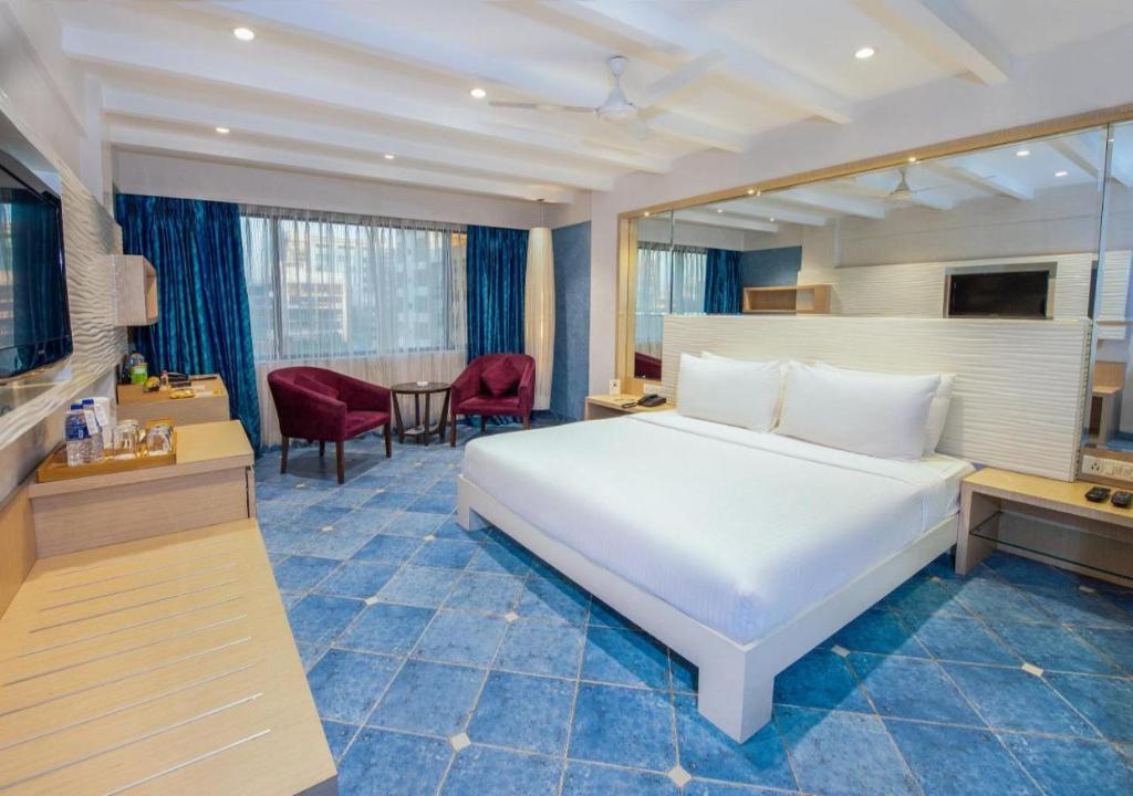 a bedroom with a large white bed and a table at Ocean Suites Near Delhi International Airport in New Delhi