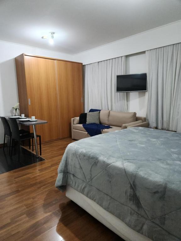 um quarto com uma cama, um sofá e uma mesa em Hotel Slavieiro Moema Suite Prime Familia em São Paulo