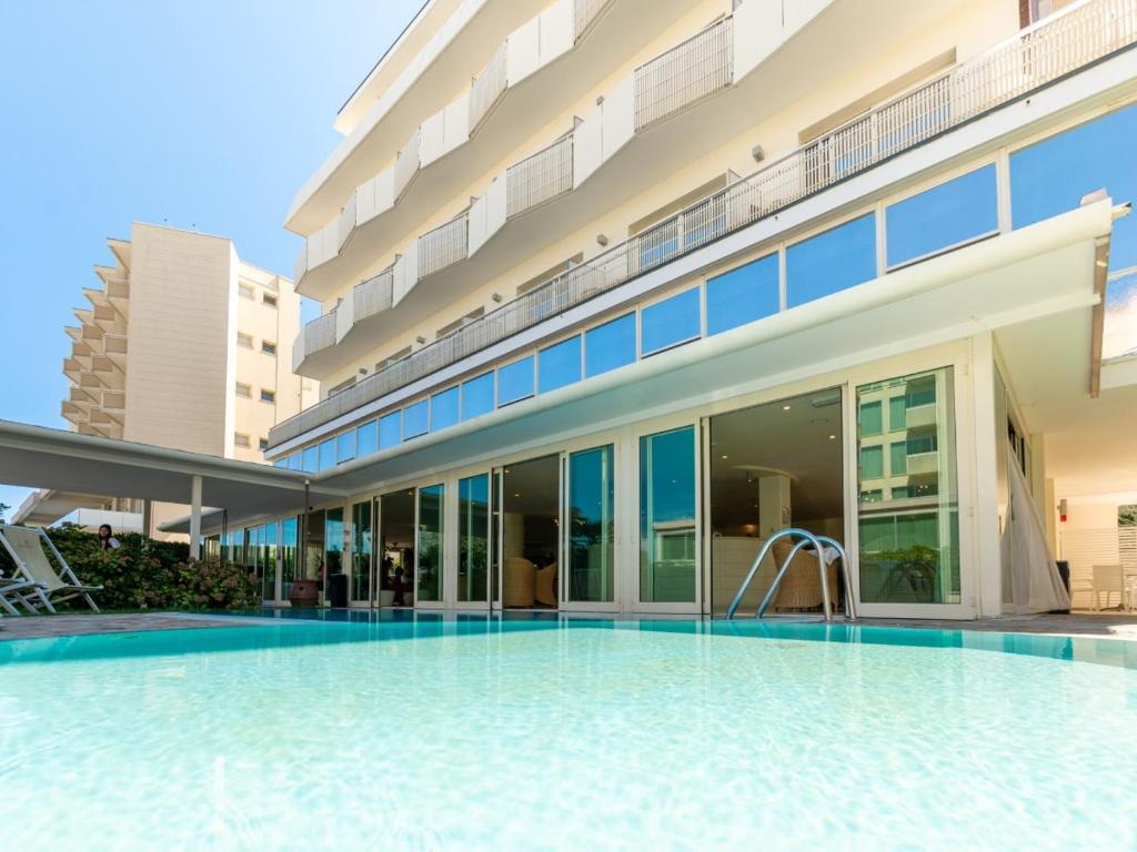 a swimming pool in front of a building at Hotel King in Milano Marittima