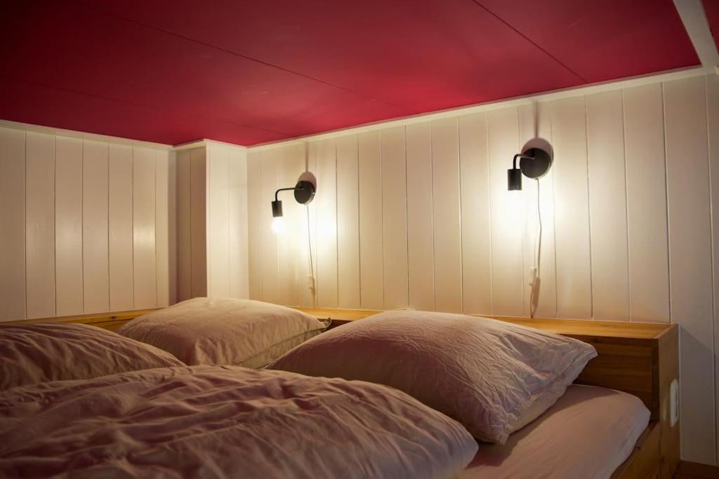 a bedroom with two beds and two lights on the wall at Drostenstraat (voor groepen) in Zwolle