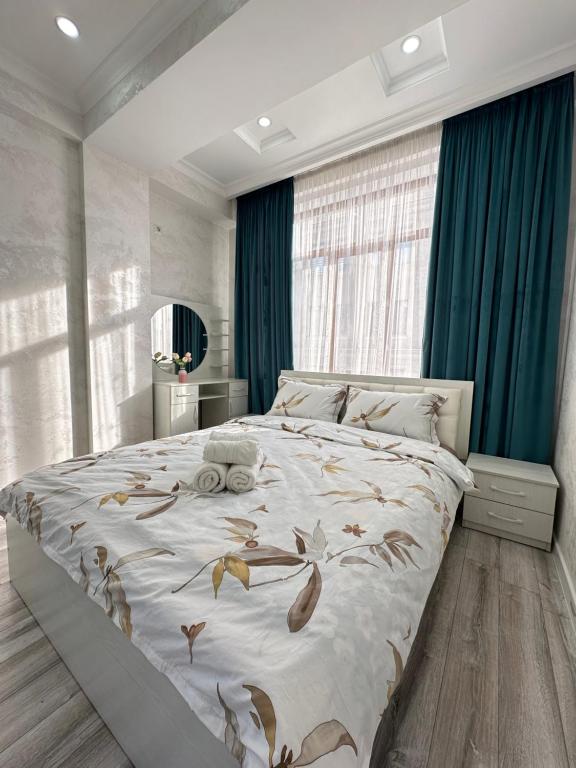 um quarto com uma cama grande com folhas em Kojomkul em Bishkek