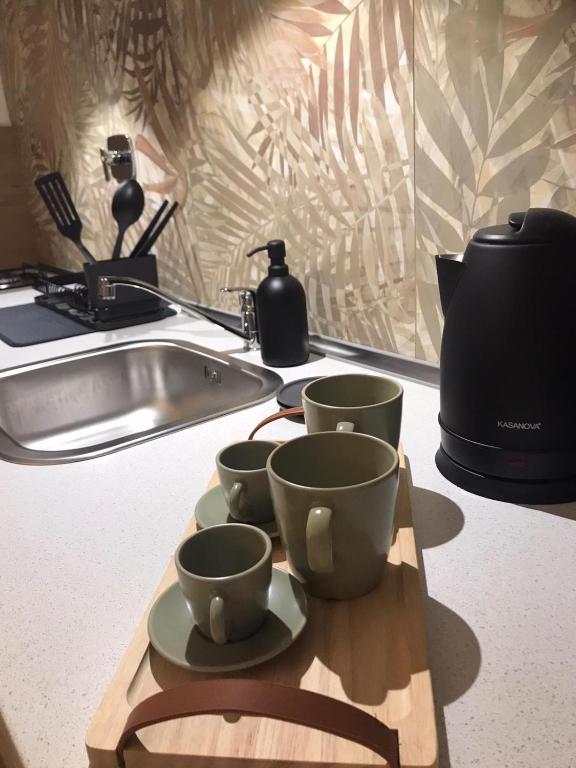 three cups on a cutting board next to a sink at Friendly House 94 in Rome