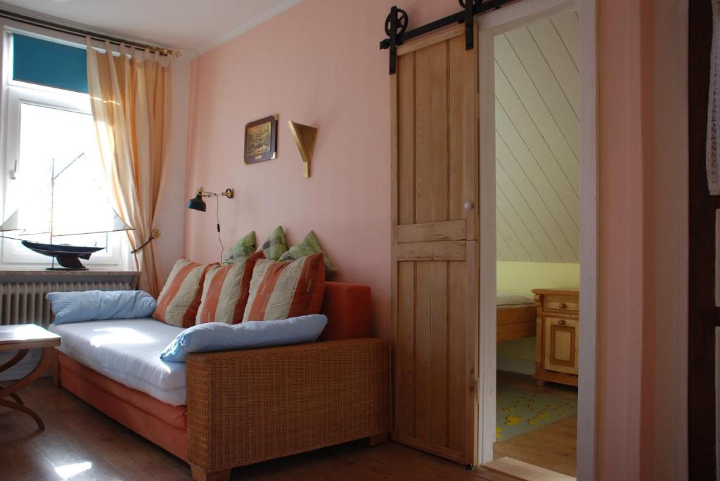 a living room with a couch and a sliding glass door at Haus Sonnensegler Ferienwohnung Luv in Cuxhaven
