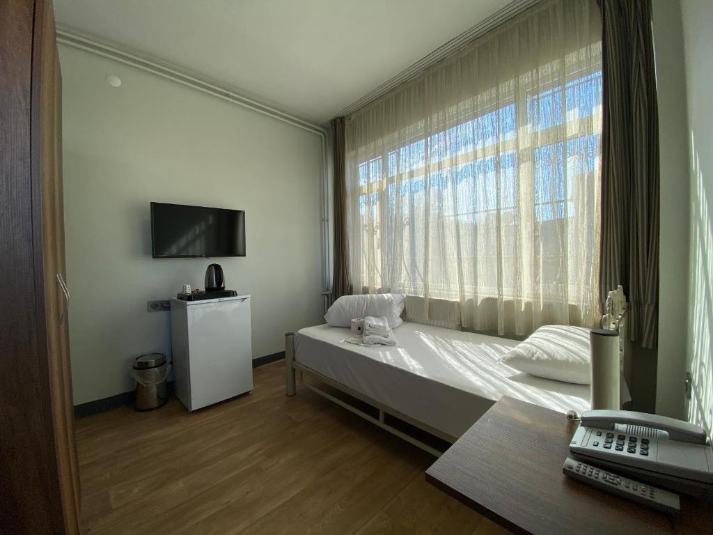 sypialnia z łóżkiem i dużym oknem w obiekcie Ferah Otel w Stambule